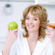 dieta po wybielaniu zębów kobieta pokazuje jabłko i słodycze